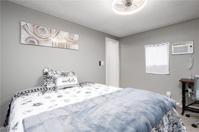 bedroom with carpet flooring, a textured ceiling, and a wall mounted air conditioner