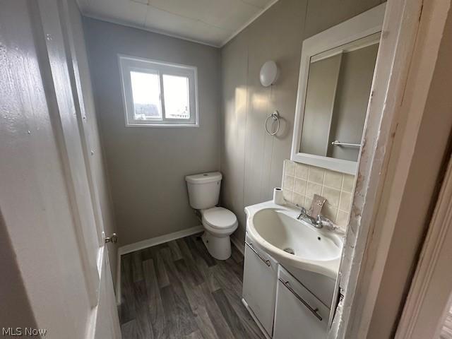 bathroom featuring vanity, hardwood / wood-style floors, decorative backsplash, and toilet