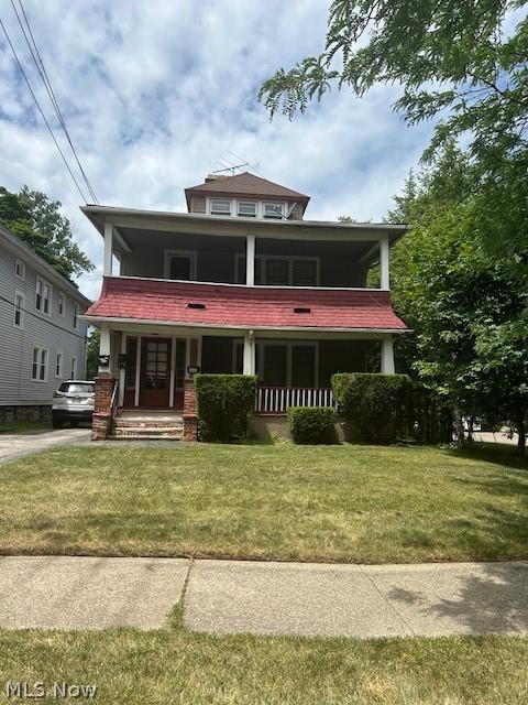 view of front of property with covered porch and a front yard