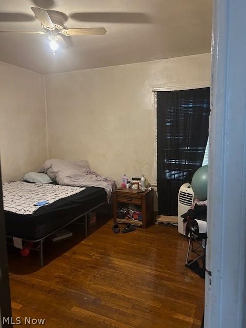 bedroom with ceiling fan and dark wood-type flooring