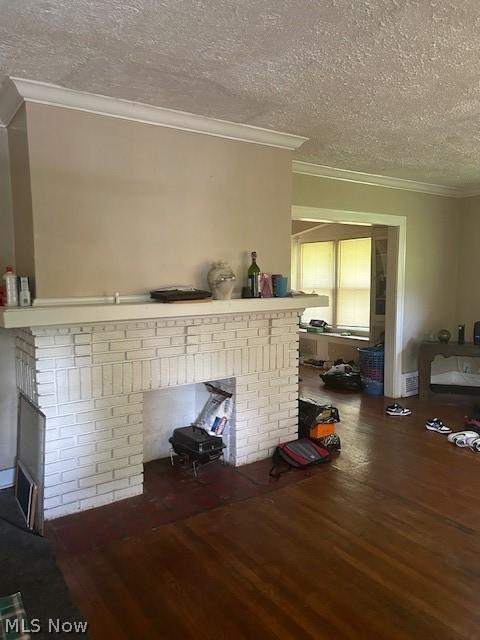 details with hardwood / wood-style floors, crown molding, a textured ceiling, and a brick fireplace