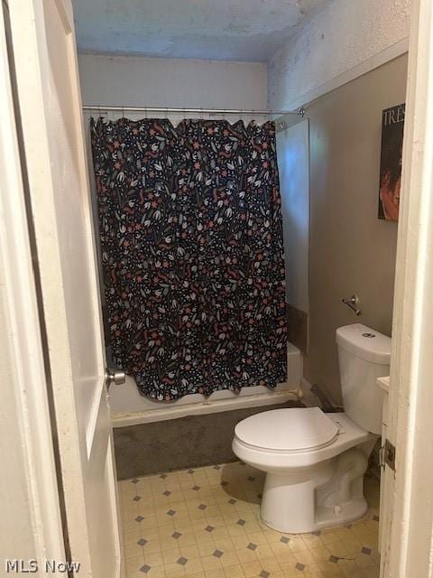 bathroom with shower / bath combination with curtain and toilet