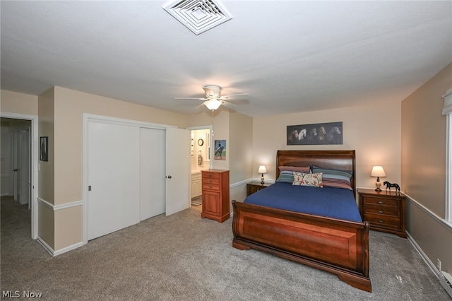 carpeted bedroom with connected bathroom, a closet, and ceiling fan