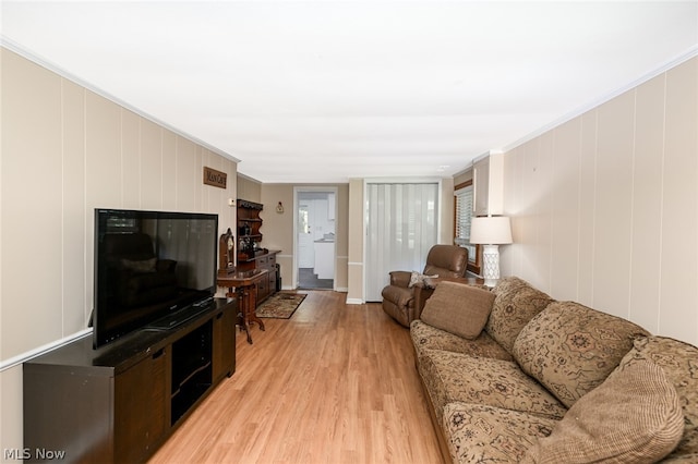 living room with ornamental molding and light wood-type flooring