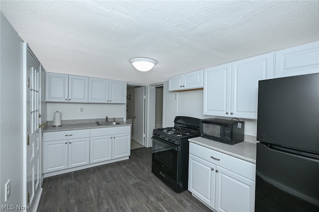 kitchen featuring black appliances, a textured ceiling, and dark wood-type flooring