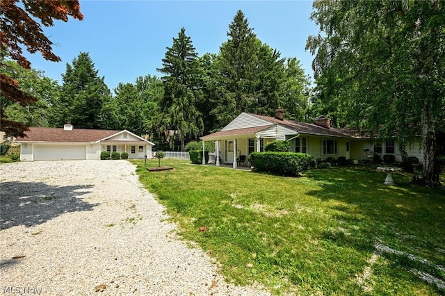 view of front of property with driveway, a chimney, a front yard, and fence