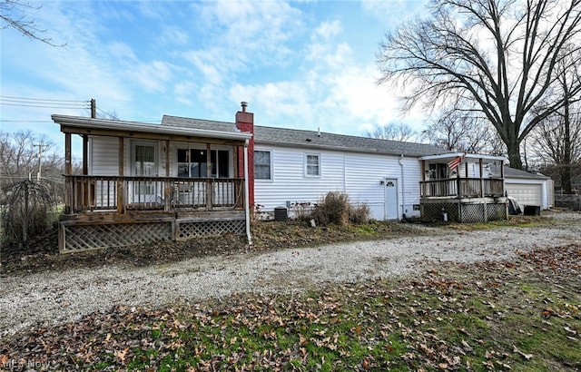 rear view of house featuring a garage and covered porch