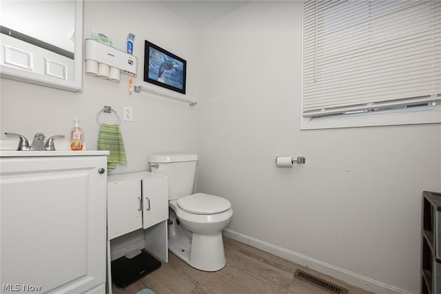 bathroom with hardwood / wood-style floors, vanity, and toilet