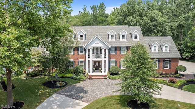 view of front of house featuring a front yard and a balcony