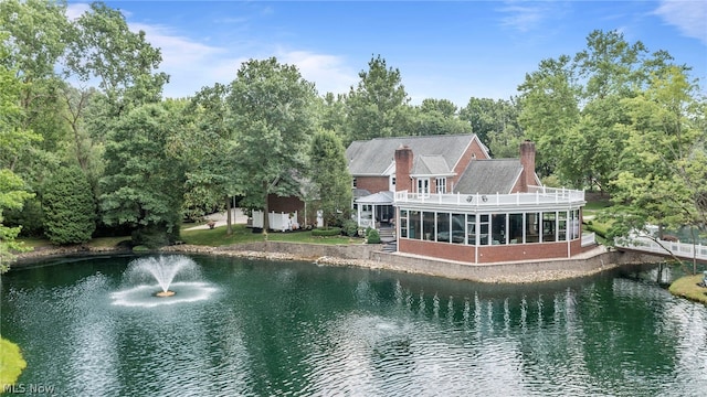 rear view of house featuring a sunroom and a water view