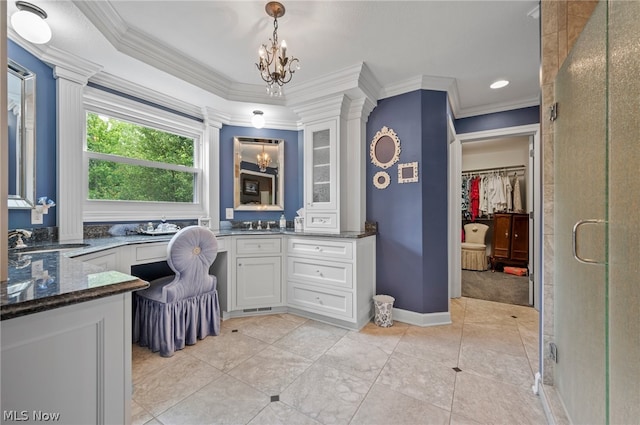 bathroom with tile flooring, walk in shower, an inviting chandelier, ornamental molding, and vanity