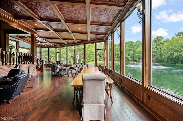 sunroom / solarium featuring coffered ceiling, beam ceiling, plenty of natural light, and a water view