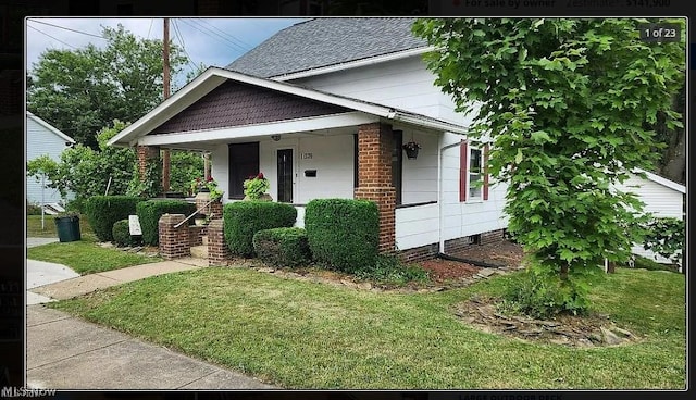 view of front of home with covered porch and a front lawn