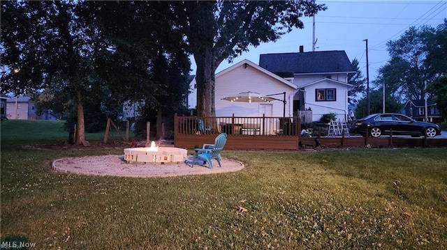 view of yard with a deck and a fire pit