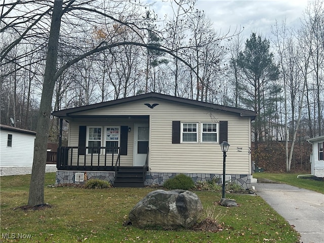 manufactured / mobile home featuring covered porch and a front yard