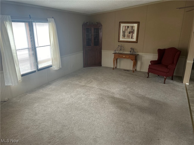 unfurnished room with carpet, a textured ceiling, and ornamental molding