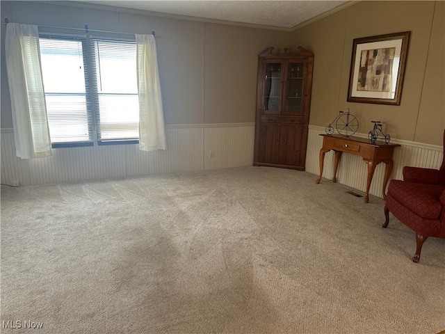 unfurnished room featuring carpet, a textured ceiling, and crown molding