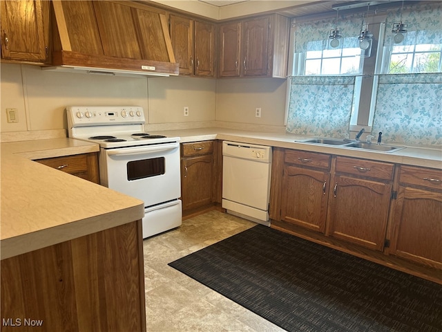 kitchen featuring custom range hood, white appliances, decorative light fixtures, and sink