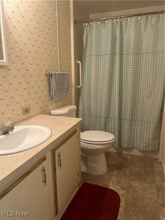 bathroom with tile patterned flooring, a shower with curtain, vanity, and toilet