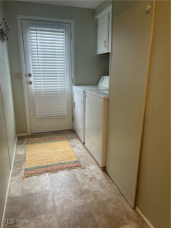 washroom featuring washer and dryer and cabinets