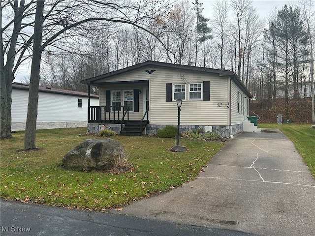 manufactured / mobile home with a front yard and covered porch