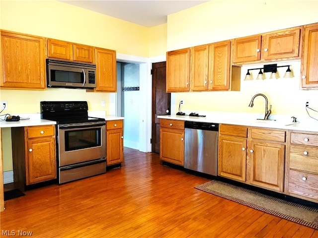 kitchen with stainless steel appliances, dark wood-type flooring, and sink