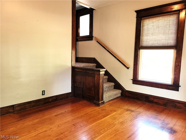 staircase with a healthy amount of sunlight and hardwood / wood-style flooring