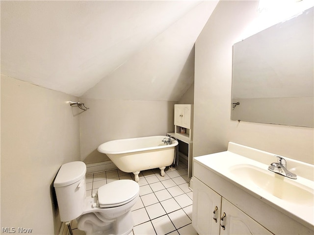 bathroom with tile floors, vaulted ceiling, a bathing tub, large vanity, and toilet