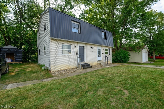 view of front of home with a garage, a front yard, and an outdoor structure