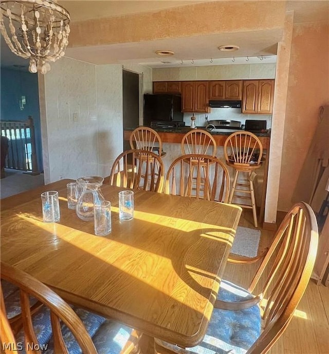 dining area featuring light hardwood / wood-style floors and a notable chandelier