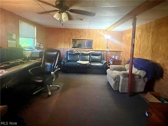 interior space with ceiling fan and wooden walls