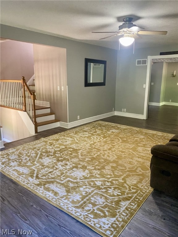 living room with ceiling fan and dark hardwood / wood-style flooring