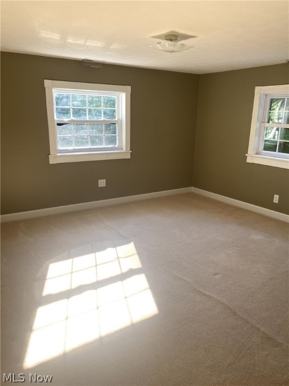 carpeted empty room featuring plenty of natural light