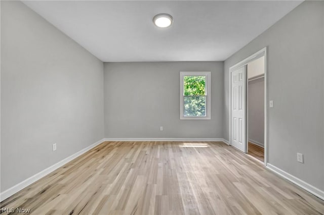 unfurnished bedroom with light hardwood / wood-style floors and a closet