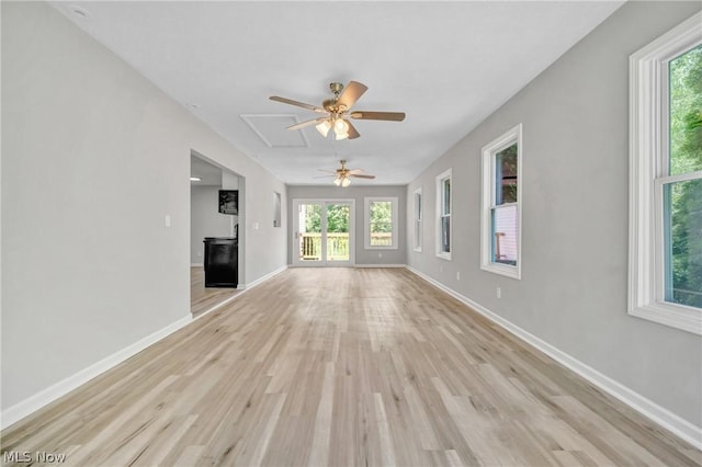 unfurnished living room featuring ceiling fan and light hardwood / wood-style floors