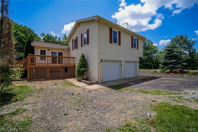 view of side of property with a wooden deck and a garage