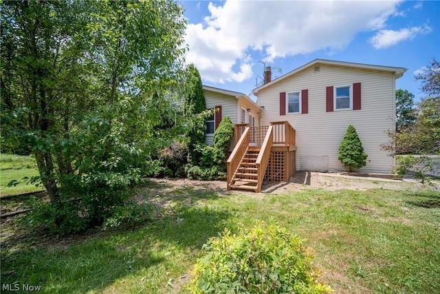 back of house featuring a yard and a wooden deck