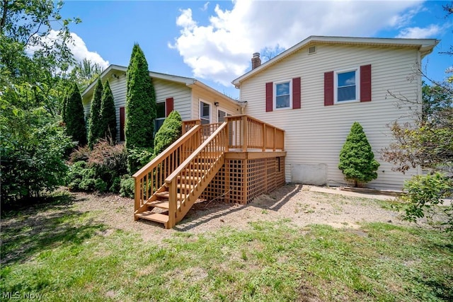 rear view of house with a yard and a wooden deck