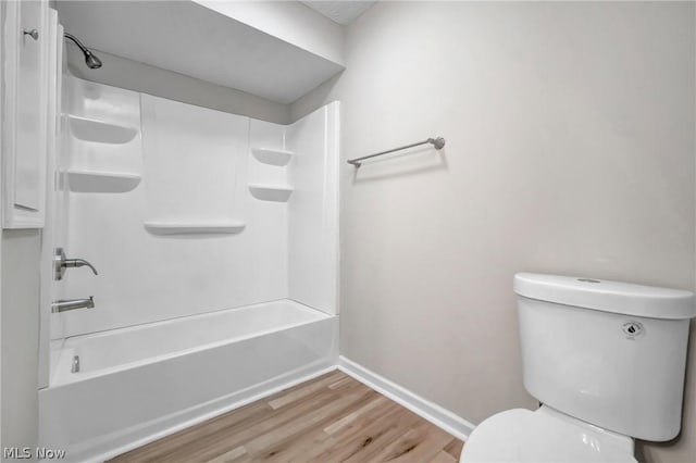 bathroom featuring shower / bath combination, hardwood / wood-style flooring, and toilet