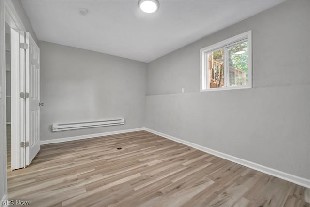 unfurnished room with light wood-type flooring and baseboard heating