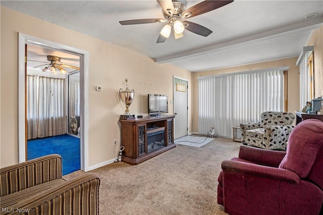 carpeted living room featuring ceiling fan and beam ceiling