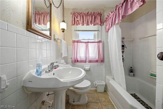 bathroom featuring tile walls, shower / bathtub combination with curtain, toilet, and tile patterned floors