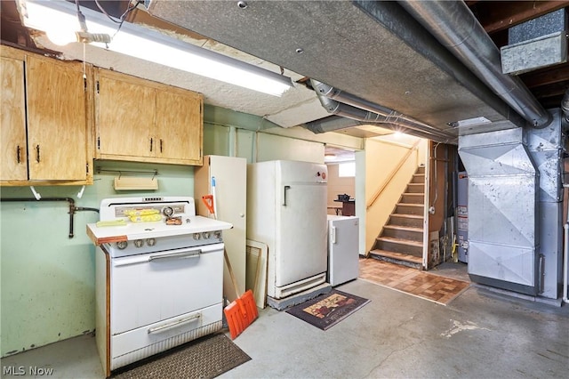 kitchen with heating unit, white appliances, and water heater