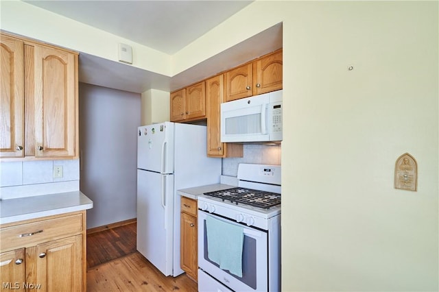 kitchen with decorative backsplash, white appliances, and light hardwood / wood-style flooring