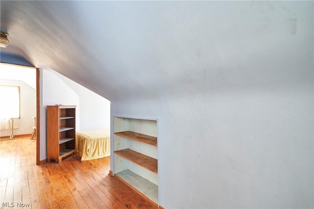 bonus room featuring light wood-type flooring and lofted ceiling