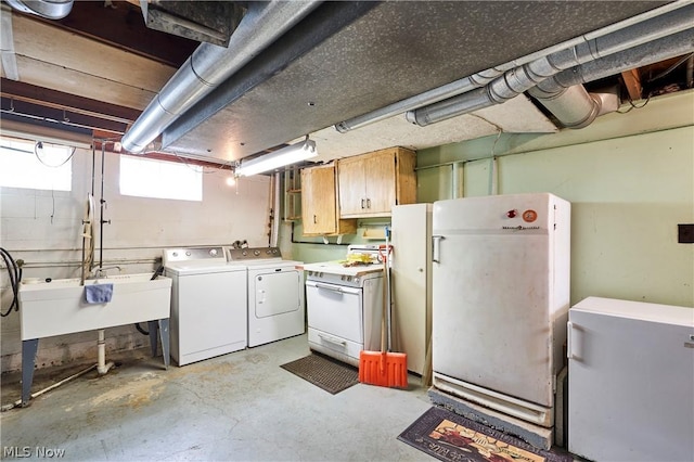 basement with washing machine and dryer, sink, and white refrigerator