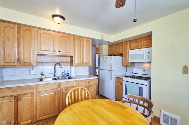 kitchen with decorative backsplash, white appliances, light hardwood / wood-style floors, and sink