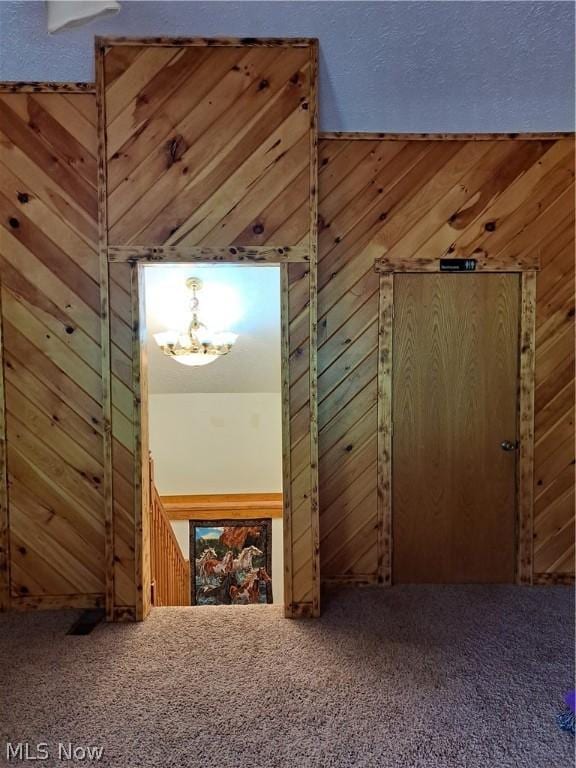 bonus room with carpet flooring and wood walls