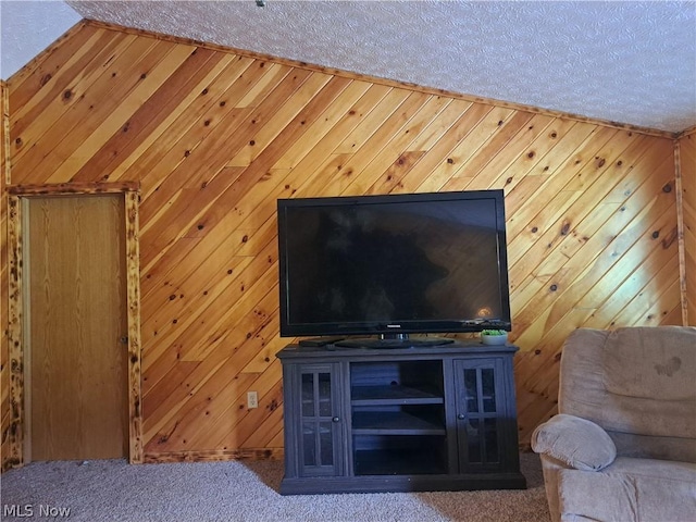 unfurnished living room with wood walls, carpet, and a textured ceiling