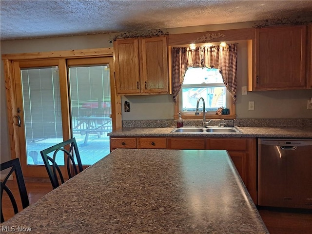 kitchen featuring stainless steel dishwasher, sink, and a textured ceiling